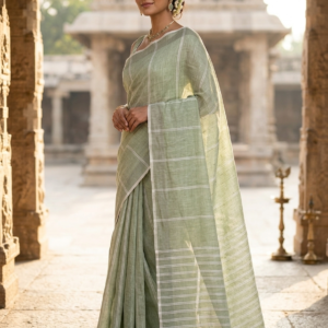 A professional fashion photoshoot of a model wearing a Sage Mist Pure Linen Saree. The saree features a soothing sage green color with delicate white vertical stripes on the body and contrasting horizontal stripes on the pallu. The pallu is finished with hand-knotted dual-tone ivory and olive tassels.